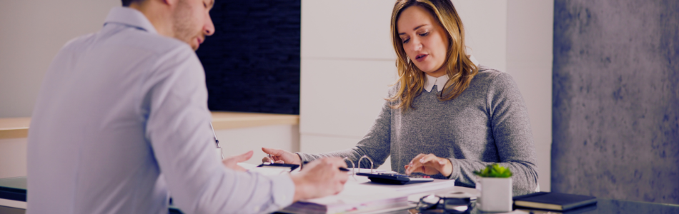work colleagues in discussion with a desk and work in between