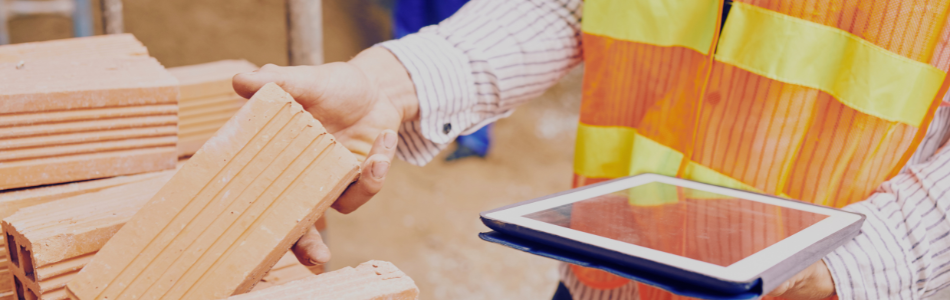 Hands holding ipad and reaching to touch building materials