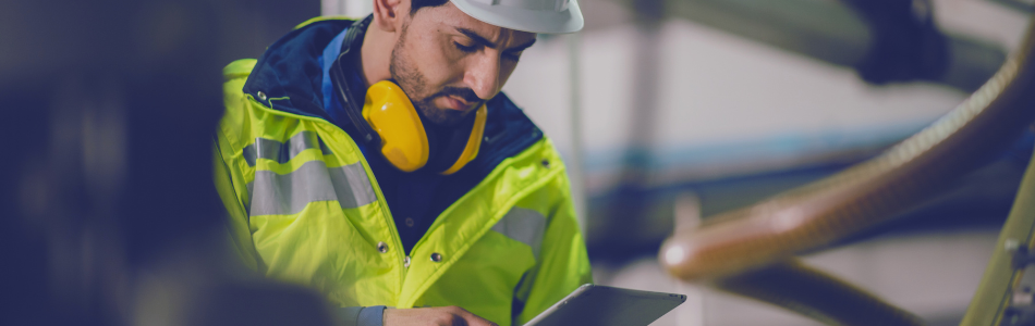 electrical engineer looking at ipad in hi-vis safety gear