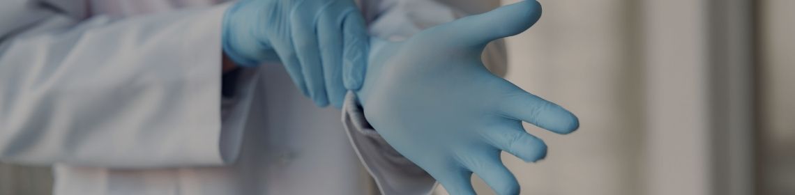 Medical professional putting on safety gloves